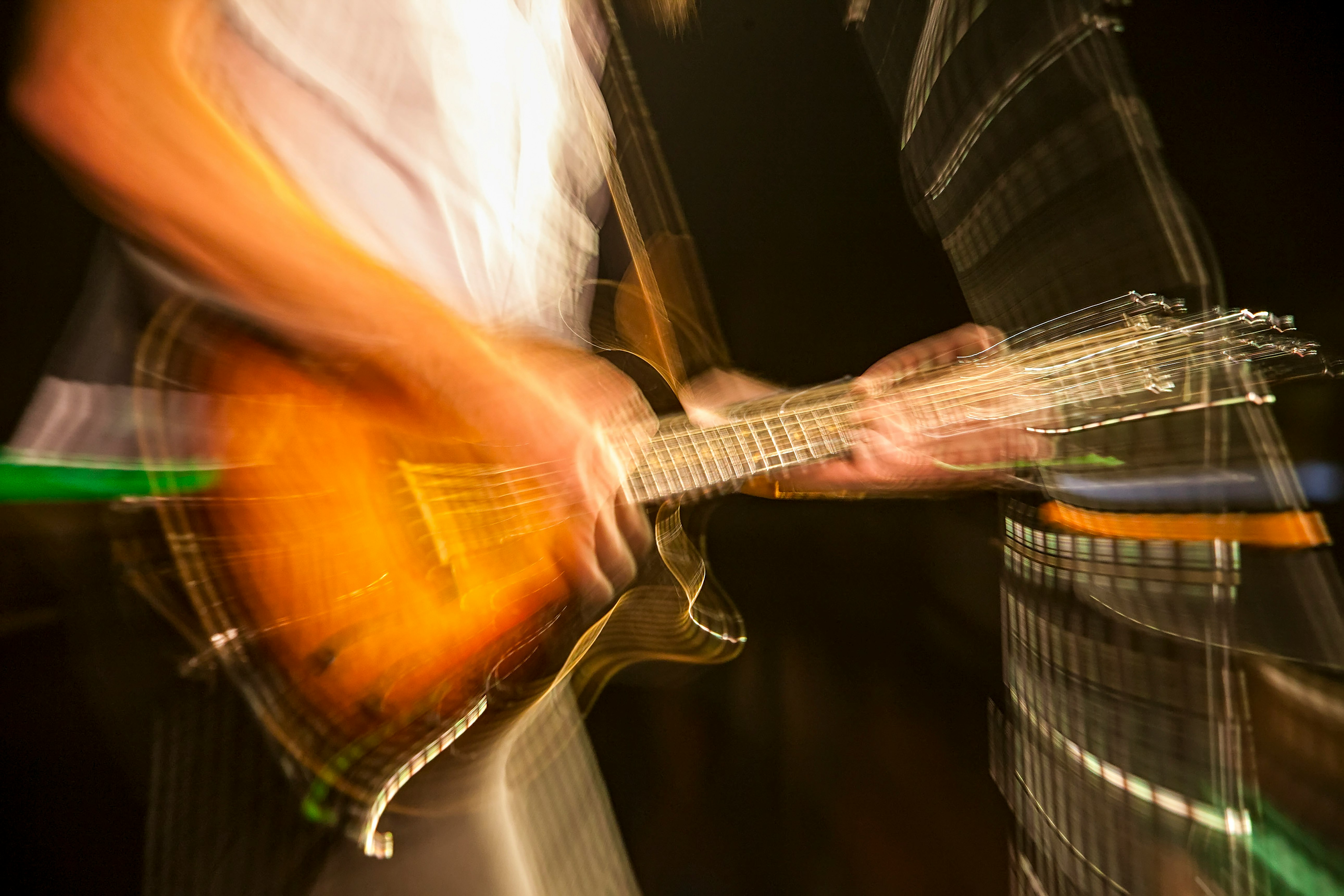 man in white shirt playing brown acoustic guitar